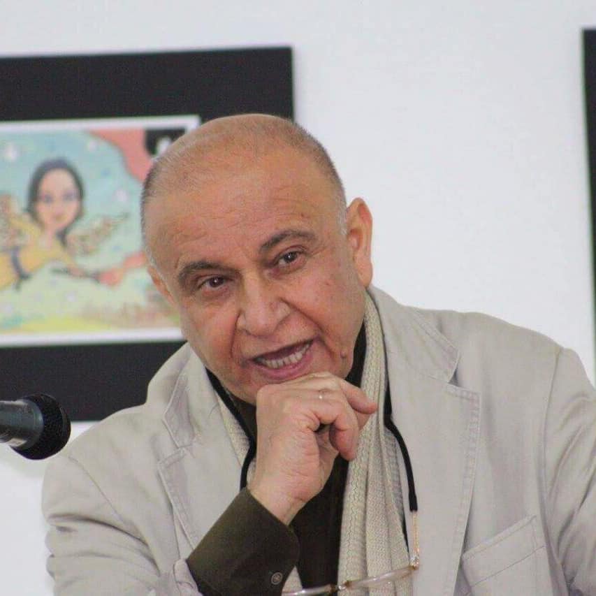 Sherzad Hassan während einer Veranstaltung beim Reden. Im Hintergrund ein gezeichneter Engel mit einer Fackel in der Hand.