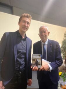 Verleger Paul Klingenberg und der österreichische Bundespräsident Alexander van der Bellen mit dem Buch "Wie der Krieg uns verändert" von Olha Volynska.
